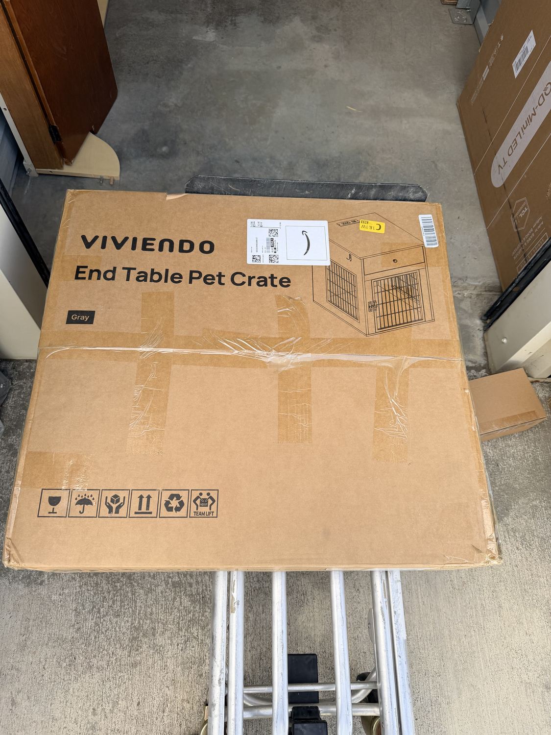 A large boxed pet crate on a hand truck