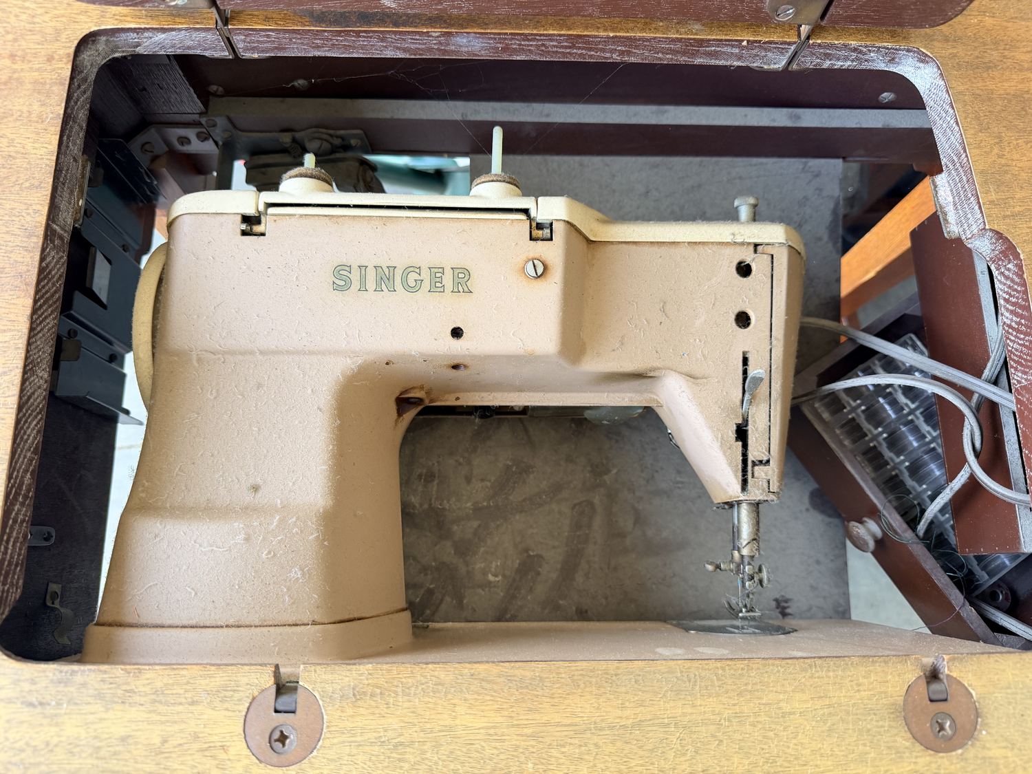 An older Singer sewing machine in its cabinet